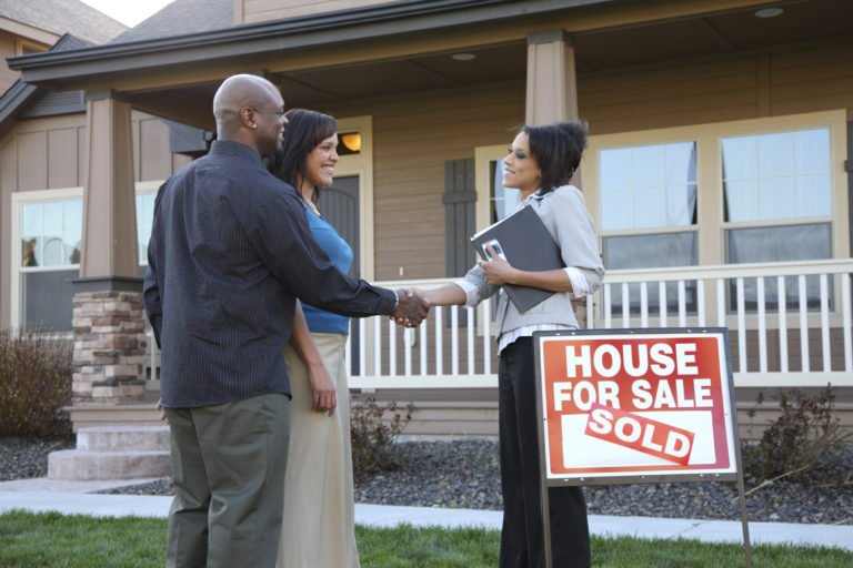 Couple shakes realtor's hand, house sold.