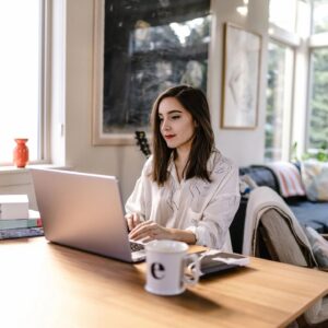 A woman sitting at a table with a laptop.
